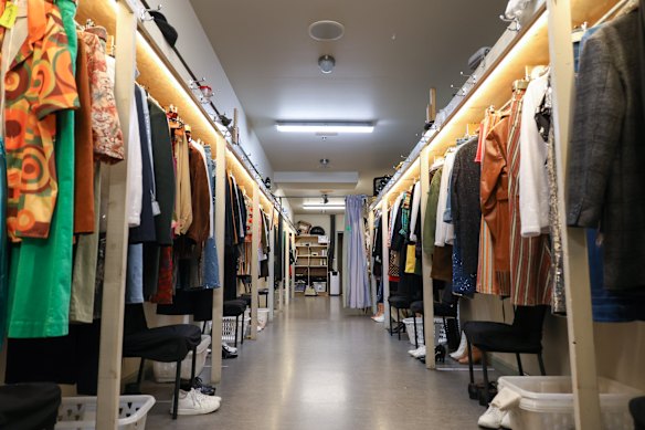 Some of the racks of costumes from the show hanging backstage.