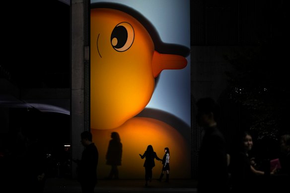 Invited guests walk by a giant poster shows one of the Louis Vuitton Women’s Voyager Pre-Fall 2024 Collection during a fashion show at the Long Museum in Shanghai, China.