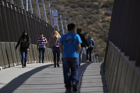 People walk on a bridge at the San Ysidro Port of Entry, connecting Tijuana, Mexico, to the United States.