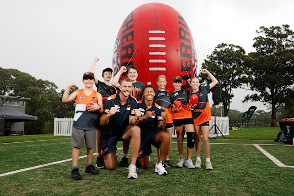 Kieren Briggs and Josaia Delana of the Giants pose for a photo with students during the Western Sydney 2025 AFL