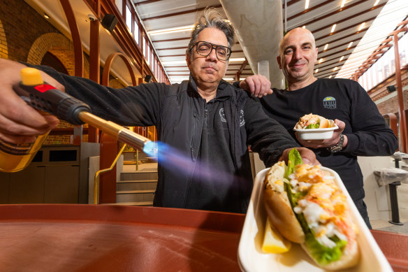 George Milonas (left) blowtorches a lobster roll as business partner Luke Louca watches on.