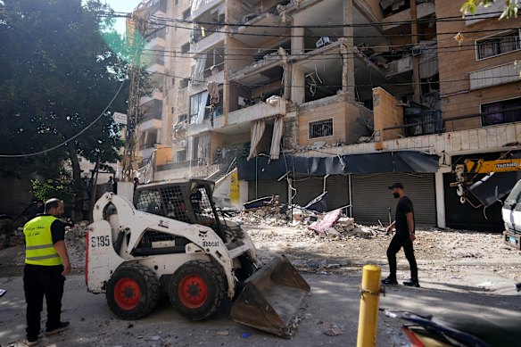 Municipality workers remove the rubble of destroyed apartments that were hit by an Israeli airstrike on Beirut’s southern suburb, Dahiyeh.