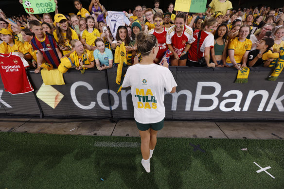 Fans push to the fence to greet the Matildas post-game.