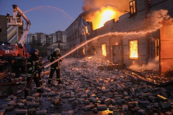 Ukrainian firefighters extinguish a blaze at a warehouse after a bombing in Kyiv, Ukraine, Thursday, March 17, 2022.