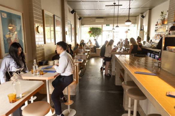 The room is dominated by a bar and open kitchen.