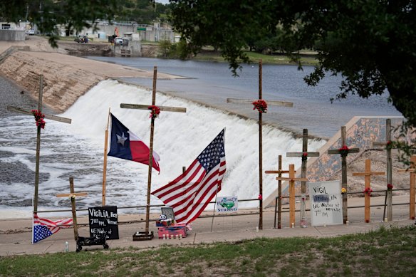 Las cruces y las banderas se exhiben en un monumento para las víctimas de inundaciones a lo largo del río Guadalupe el viernes.