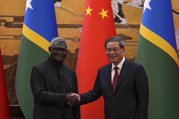 Visiting Solomon Islands Prime Minister Manasseh Sogavare shakes hands with Chinese Premier Li Qiang.