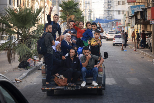 Palestinians flee Gaza City after Israeli air strikes on Friday.