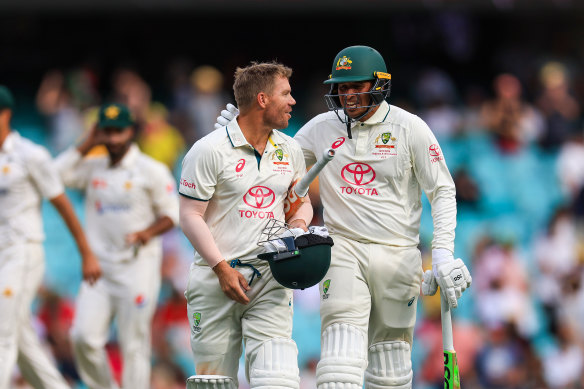 David Warner of Australia and Usman Khawaja of Australia leave the pitch at stumps on day one.