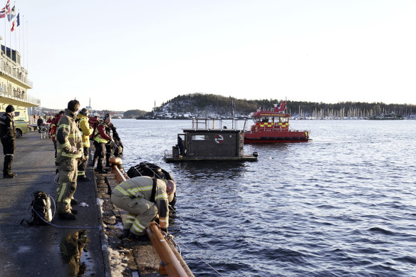 The car is retrieved from the water  in front of the floating sauna after driving out into the Oslofjord, in Oslo.