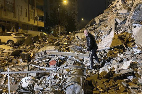 A man searches collapsed buildings in Diyarbakir, Turkey.