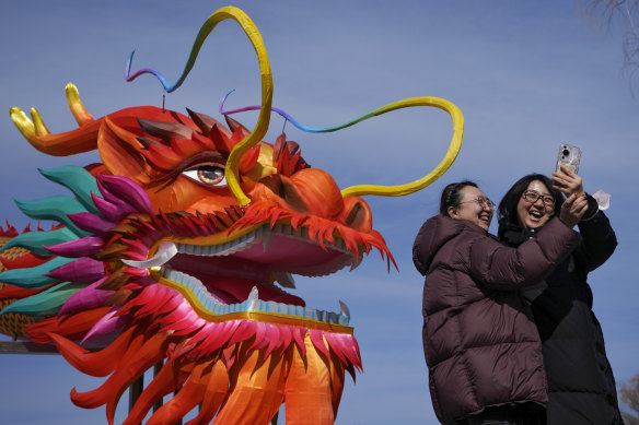 Women take a selfie with a giant dragon lantern in Beijing.