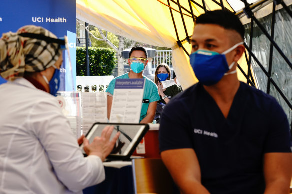 Get that jab: Healthcare workers wait to receive the Pfizer-BioNTech COVID-19 vaccine at UCI Medical Centre in California on Wednesday.