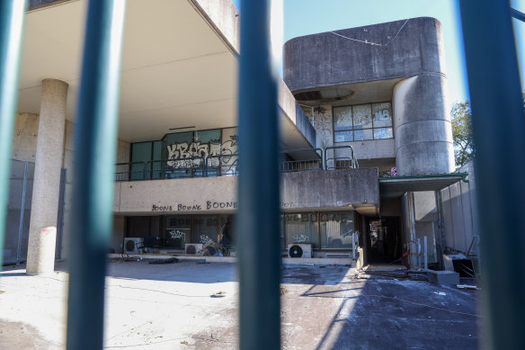 The building’s concrete walls are covered in graffiti and its glass windows and doors have been shattered. Inside, office chairs, desks, partitions, drawers and bookshelves have been trashed.