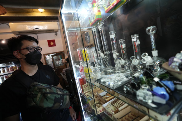 A customer views an array of paraphernalia used to smoke marijuana at the Highland Cafe in Bangkok, Thailand.