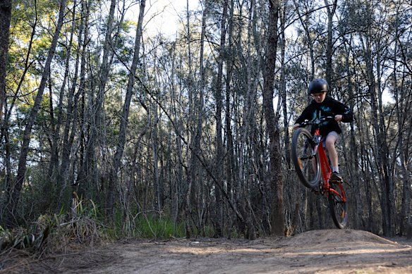 Kids ride their bikes on an unofficial BMX track.