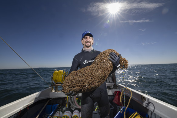 Scott Breschkin holds a coir bag containing thousands of shells.