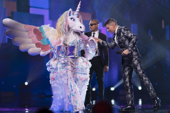 The Masked Singer contestant Unicorn with the show's host Osher Günsberg. 
