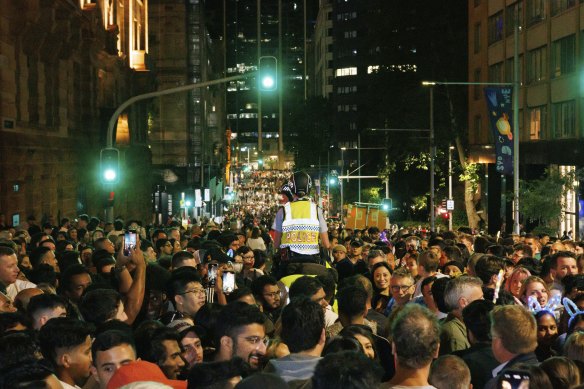 Mounted police push through a crowd gathered at the intersection of Young St and Bridge St to try and get a glimpse of Sydney’s midnight New Year’s Eve fireworks.