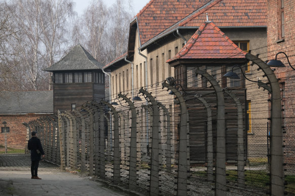 A visitor walks behind the barbed wire of the former Auschwitz-Birkenau concentration camp.