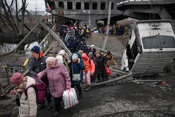 People cross on an improvised path under a bridge that was destroyed by a Russian airstrike outside Irpin. 