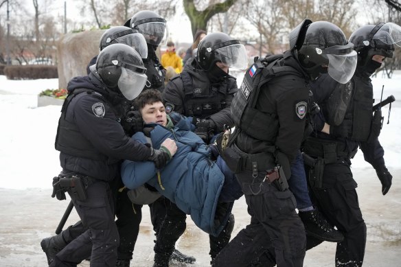Police detain a man when he tried to lay flowers in memory of Navalny at memorials to the victims of Soviet-era purges.
