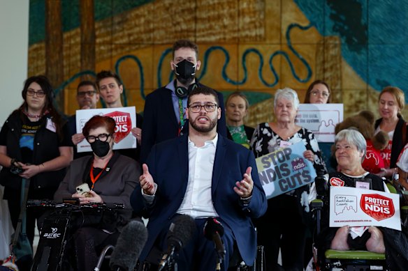 Greens senator Jordan Steele-John with NDIS advocates at the post-budget press conference in Parliament House.