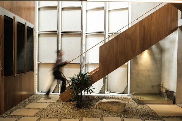 The indoor/outdoor space features a retractable roof and a sculptural staircase made from blackbutt and brass.