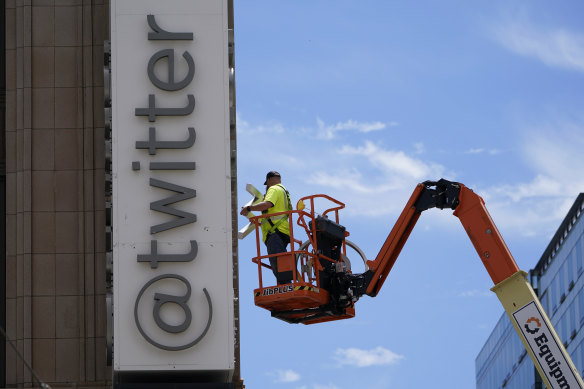 A workman removes a character from a sign on the Twitter headquarters building in San Francisco.