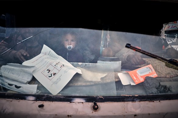 A young child looks through a truck’s windshield as displaced families prepare to leave al-Talayi camp in Hassakeh, Syria. Around 450 families are returning to the Ras al-Ayn countryside, seven years after a Turkish military offensive forced them to flee.