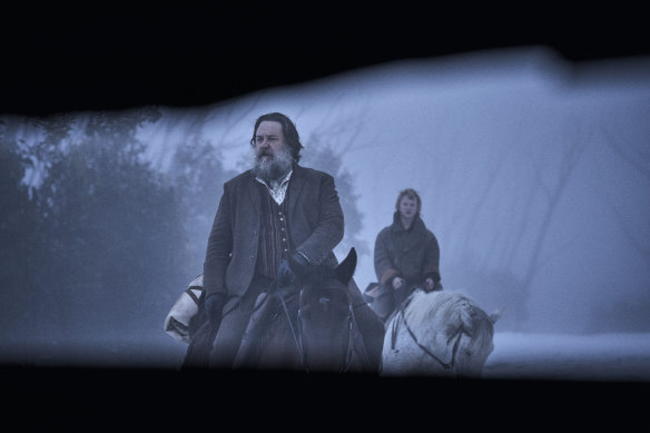 Harry Power (Russell Crowe) and young Ned (Orlando Schwerdt) glimpsed through a slit in Harry's hideaway.