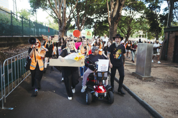 Attendees at the No More: National Rally Against Violence walked past areas fenced off due to asbestos contamination in Belmore Park, Haymarket. 