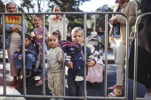 Shorter Australians look through the fence for a view of the parade. 