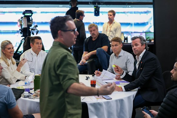 Rebecca Maddern, Luke Hodge, Daniel Edwards, Brian Taylor, Kane Cornes and Hamish McLachlan in a pre-match meeting. 