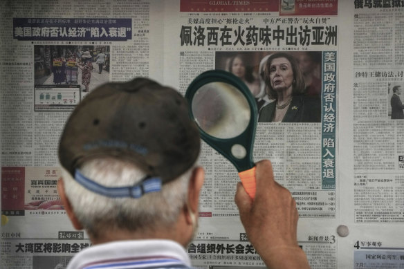A Beijing resident reads a newspaper headline reporting on US House Speaker Nancy Pelosi’s Asia visit.