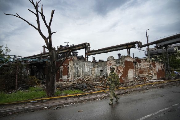 A Russian soldier patrols a destroyed part of the Illich Iron & Steel Works Metallurgical Plant in Mariupol.