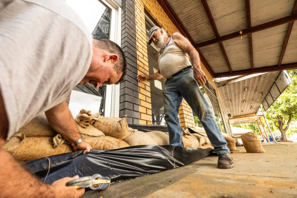 Luke Ryan and Robert Seabrook sandbagging shops in Rochester on Monday.