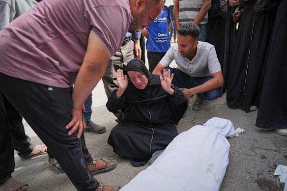 Hanan Al-Aloul on Sunday mourns over the body of a relative killed when an Israeli army strike hit their home in Gaza City.