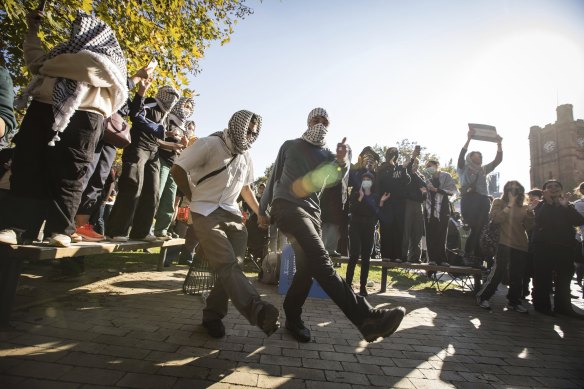 People dancing at the protest camp as crowds gather outside.