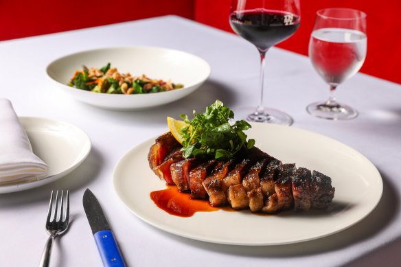 Kidman dry-aged sirloin on the bone, with coal-roasted greens, fried onion and black garlic.
