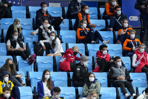 Athletes wearing face masks watch the action at the ISU World Cup Short Track speed skating competition, a test event for the Winter Olympics.