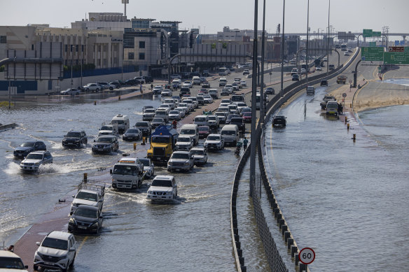 Vehicles drive through floodwater caused by heavy rain in Dubai last month.