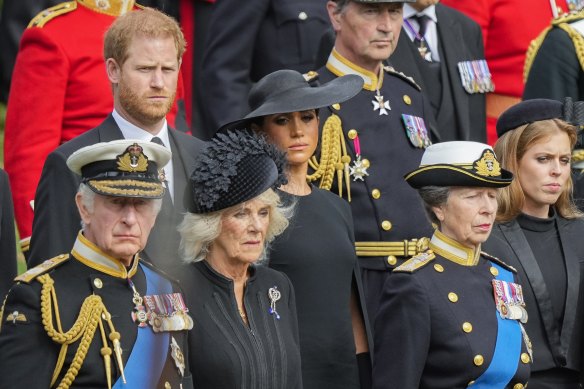 Prince Harry and Meghan, Duchess of Sussex stand behind King Charles III and Camilla, Queen Consort as the coffin of Queen Elizabeth II is placed into the hearse following the state funeral.