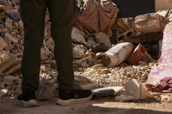 Después de un ataque aéreo israelí en Dahiyeh, un hombre se encuentra junto a un cohete sin explotar en el lugar del accidente.