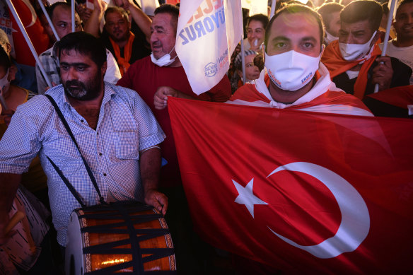 Supporters of the newly-elected Turkish Cypriot leader Ersin Tatar hold a Turkish flag and celebrate winning, in the Turkish occupied area in the north part of the divided capital Nicosia, Cyprus on Sunday.