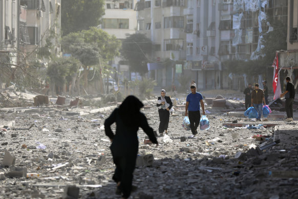 Palestinians leave their homes following Israeli bombardment on Gaza City on Monday.