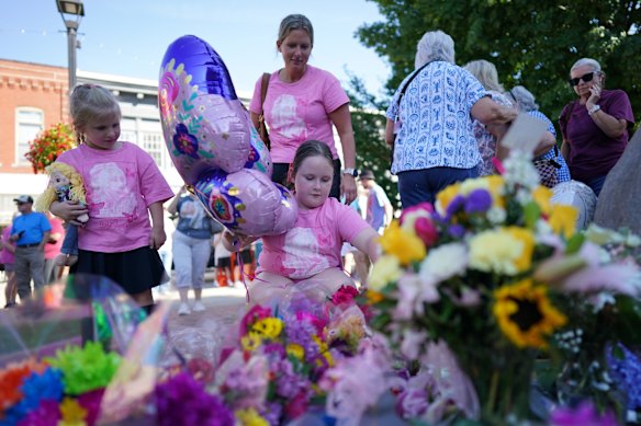 People visit a makeshift memorial honoring Dolly Parton at a statue of her in Sevierville, Tennessee, near her birthplace.