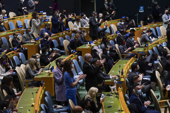 United Nations members stand up and applaud after a vote on a resolution concerning Ukraine.