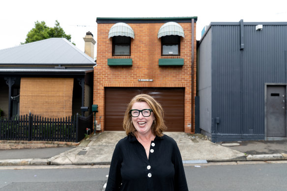 Sandy Weir, author of Other People’s Homes, stands outside one of the homes she photographed in Balmain that looks like a face.