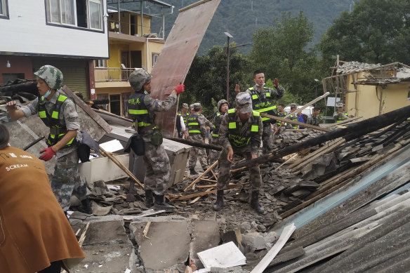 Soldiers clear debris searching for earthquake survivors.